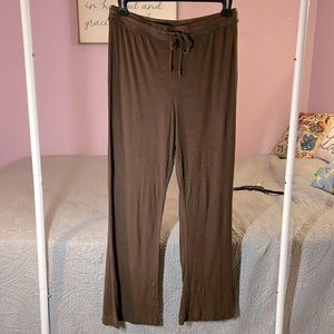 Out from under lounge pants. Small slit on outer side of each leg. Elastic waist